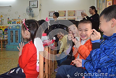 CANTON, CHINA â€“ CIRCA MARCH 2019: Smiling boys watching performance of their classmates in kindergarten. Editorial Stock Photo